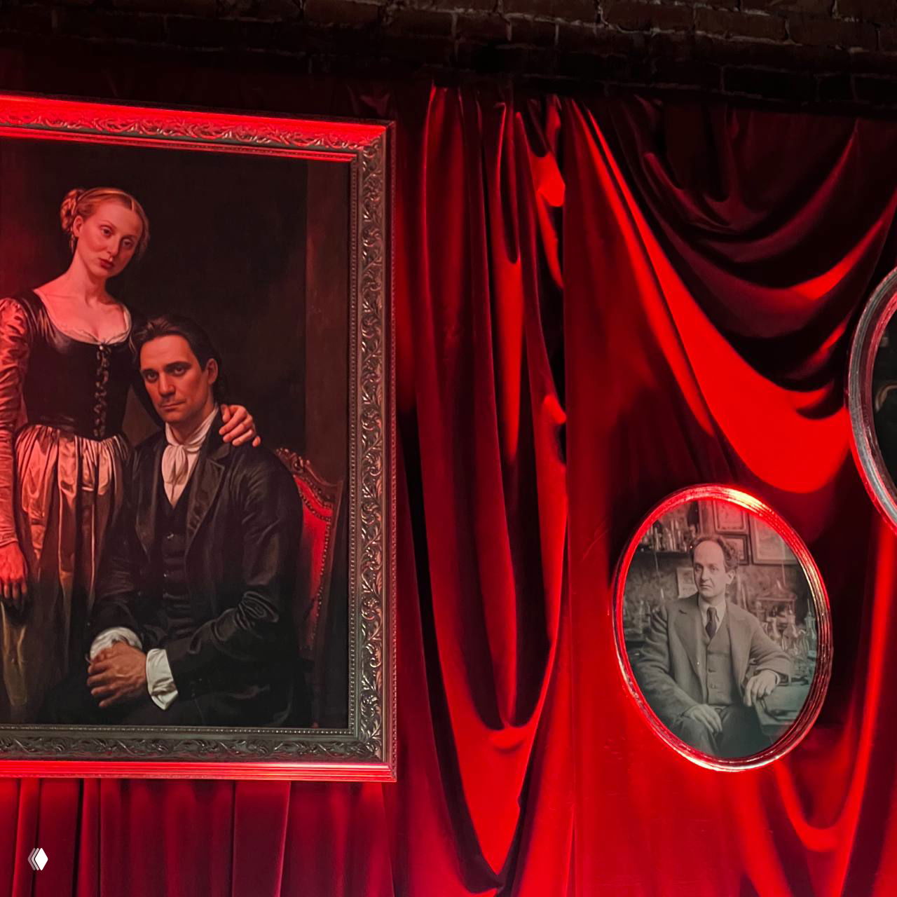 Ряд картин и круглых портретов в рамах на фоне бархатных красных штор — декоративная экспозиция в зоне презентации сериала.