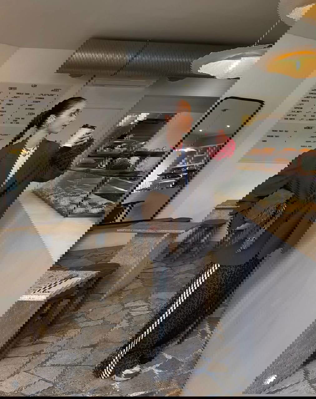 Образ в кафе: широкие брюки с белыми лампасами в сочетании с жакетом и леопардовой фактурой, витрина пекарни на заднем плане