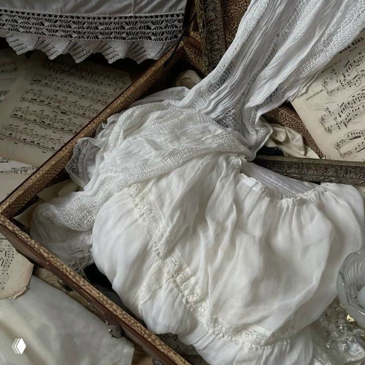 Антикварная шкатулка с белым кружевным бельём и нотными листами, текстурные ткани и ощущение старинной коробки с сокровищами.