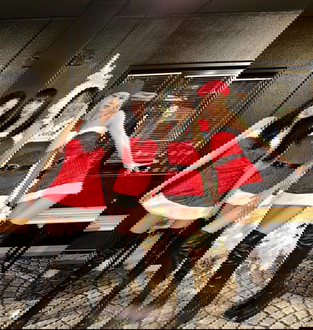 BLACKPINK в красных костюмах Санта и высоких ботфортах на фоне украшенной белой ёлки, участницы в рождественских образах и позах