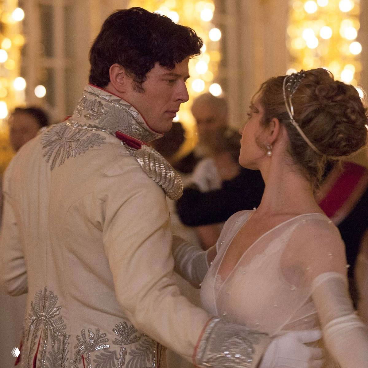 Кадр бала: мужчина в мундире и женщина в бальном платье, золочёное освещение и историческая интерьерная эстетика, как в классическом романе.