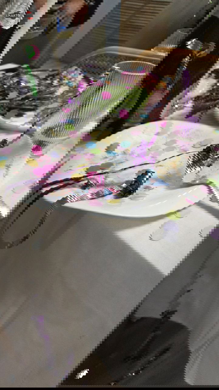 Праздничный стол после застолья: пустые тарелки, бокалы и цветное конфетти на скатерти — следы прошедшего новогоднего веселья