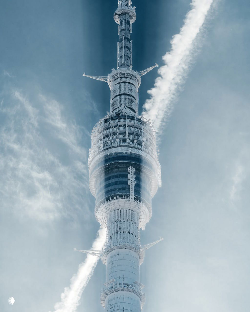 Близкий план верхней части Останкинской телебашни с обледеневшими конструкциями и следом от самолёта в небе — суровая зимняя атмосфера.