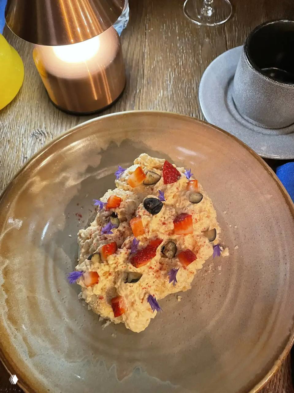 Общий вид сцены и партера: исполнители в торжественных костюмах и заполненный зал зрителей с телефонами внизу.