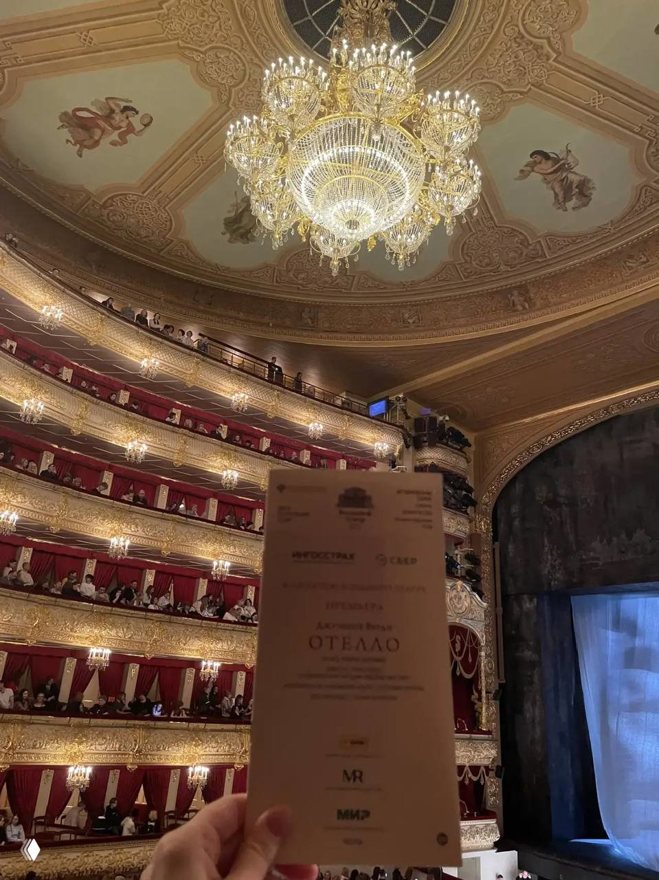 Крупный план десерта — «рваный» Наполеон с ягодами и съедобными цветами на тарелке в уютной сервировке.