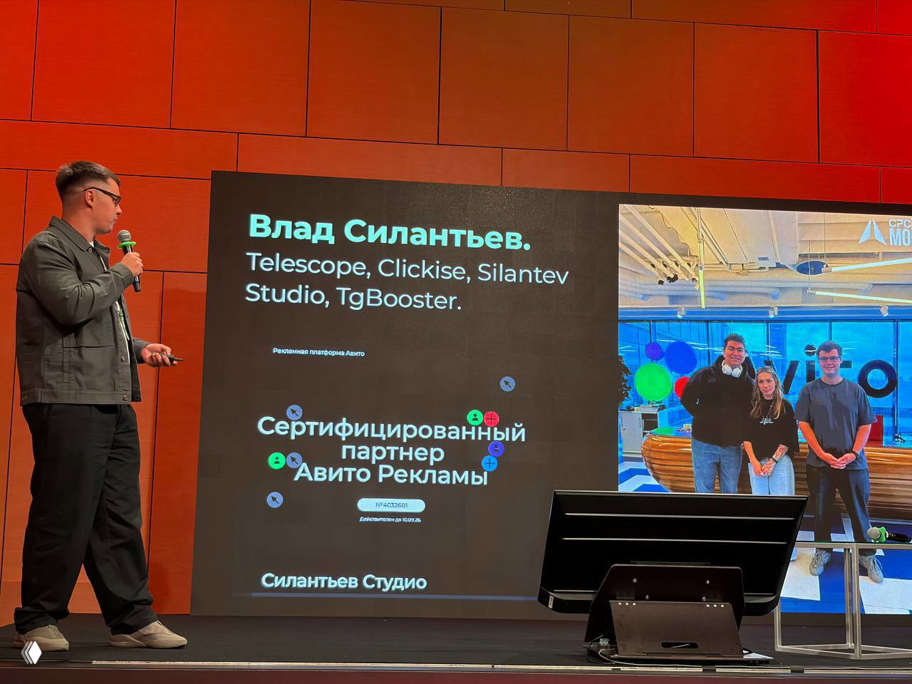 Доклад Владa Силантьева на сцене: спикер стоит рядом с большим экраном, на котором перечислены Telescope, Clickise, Silantev Studio и TgBooster.