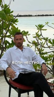 Мужчина в белой рубашке сидит на кресле у берега моря среди тропических растений; на изображении виден текст «ЕСЛИ ЧЕСТНО...» в кадре, создающий атмосферу рассуждения автора.