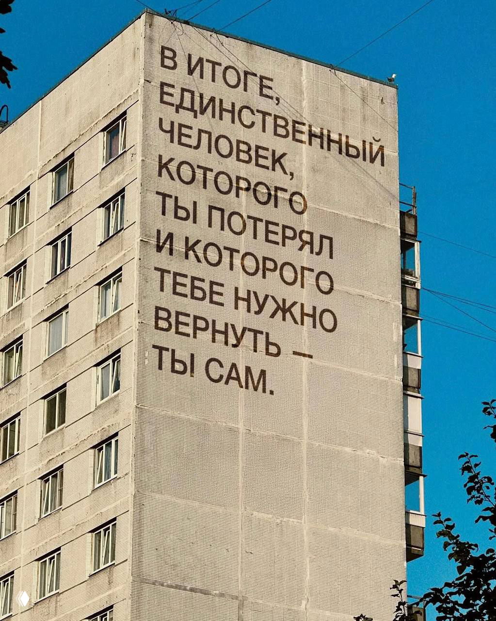 Крупный фасад дома с текстом на русском: рассуждение о том, что единственный человек, которого нужно вернуть — ты сам; урбанистическая эстетика.