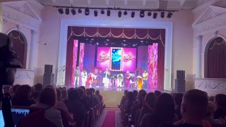 Зрительный зал и сцена театра «Париж» во время премьеры «Салон красоты»: актёры на сцене и аплодирующая публика в зале.