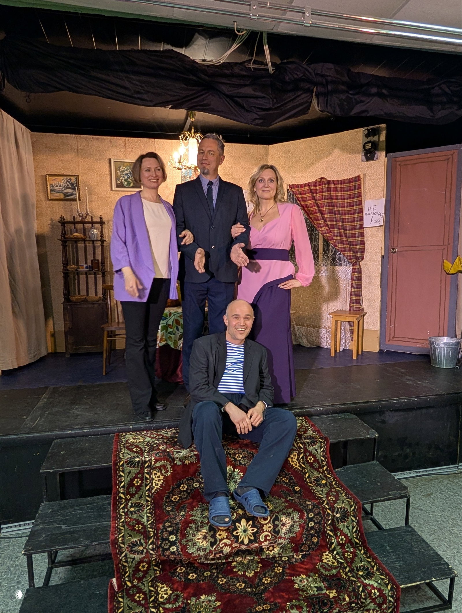 Общий кадр: актёры выходят на поклон на маленькой сцене, на переднем плане ступени с ковром и улыбчивый актёр в полосатой тельняшке.