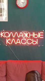 Неоновая вывеска «КОЛЛАЖНЫЕ КЛАССЫ» на зелёной стене мастерской; внизу красный диван и фрагмент головы участницы, на стене видны часы.