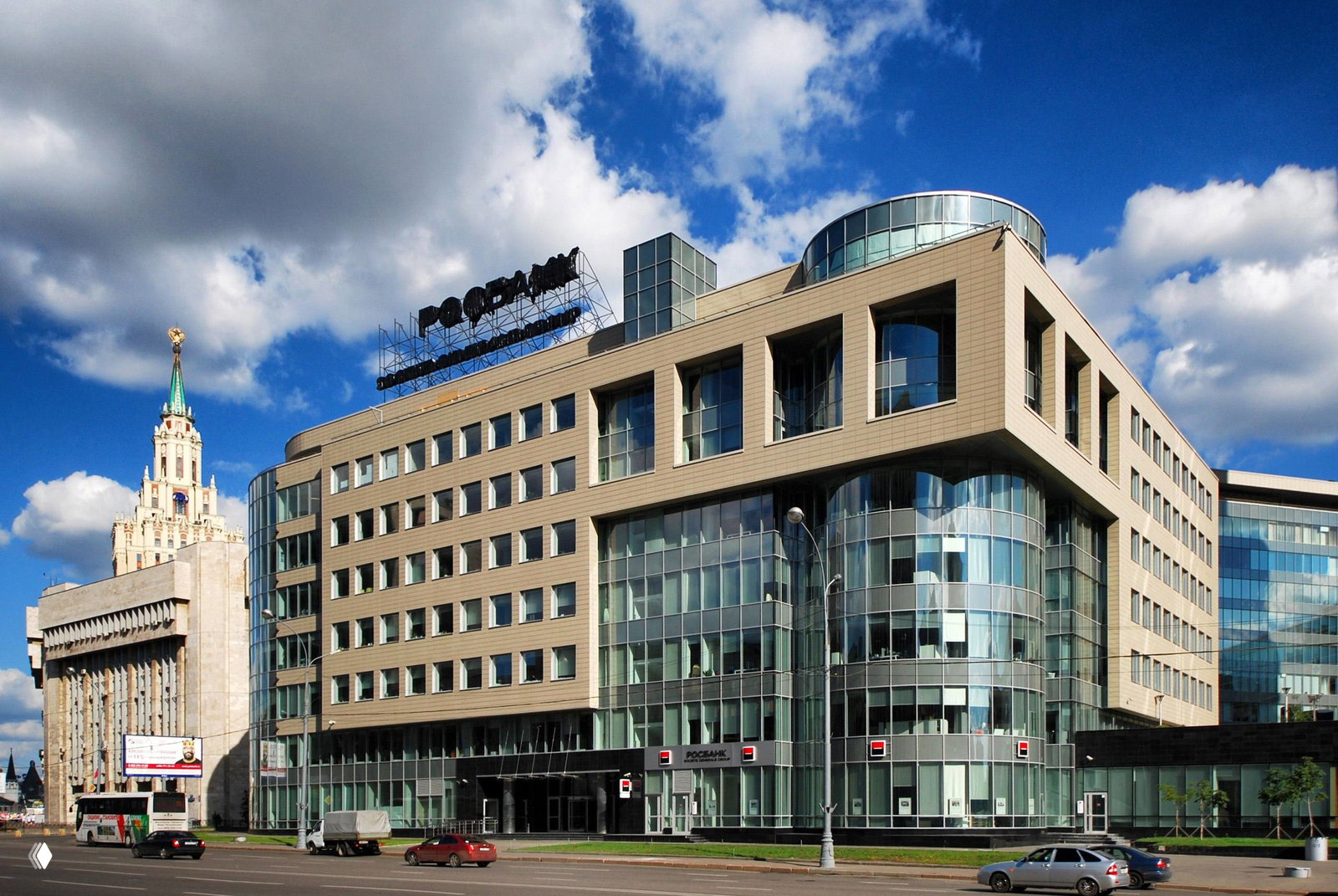 Фасад офисного комплекса у проспекта Сахарова с большими витражами и отделкой, вид на входную группу и проезжую часть в контексте городской улицы.