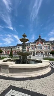 Фонтан на открытой площади на фоне архитектурного фасада в курортной зоне Геленджика, ясное небо и благоустроенная пешеходная зона вокруг.
