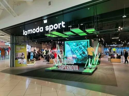 Фасад Lamoda Sport в торговом центре: яркая витрина, демонстрационная зона и экспозиция спортивных товаров у входа