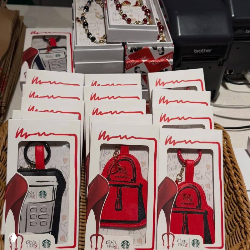 Ряд упаковок с брелоками и аксессуарами на прилавке: карточные держатели и мини‑рюкзачки с фирменной визуальной стилистикой дропа.