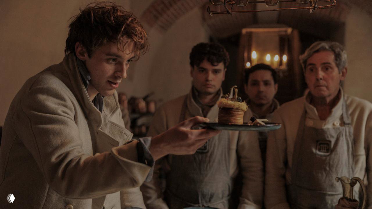 Повар подаёт маленькое сложное пирожное группе учеников/поваров, демонстрация техники и подачи блюда.