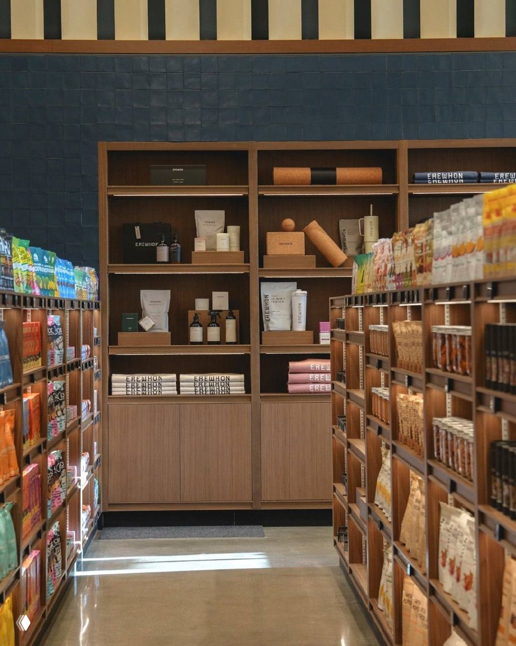 Внутренний вид магазина Erewhon: деревянные стеллажи с аккуратно выставленными упаковками, ровные ряды товаров и минималистичный интерьер.