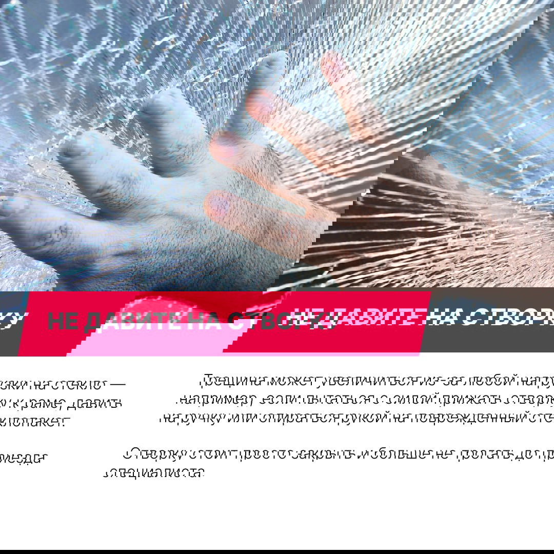 Рука, прикасающаяся к разбитому стеклу с расходящимися трещинами — демонстрация риска увеличения повреждения при давлении на створку.