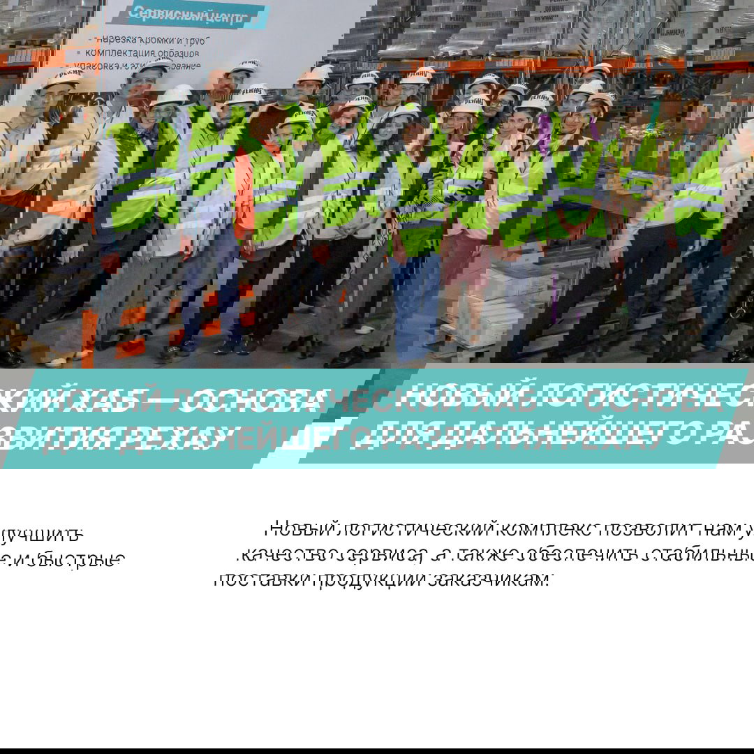 Групповое фото команды РЕХАУ в касках и сигнальных жилетах на территории склада — сотрудники сервиса и логистики собраны вместе.