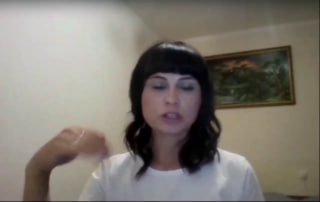 Кадр из видео: женщина в домашней обстановке говорит в камеру, видна картина на стене — превью практики 'Зелёная паста'.
