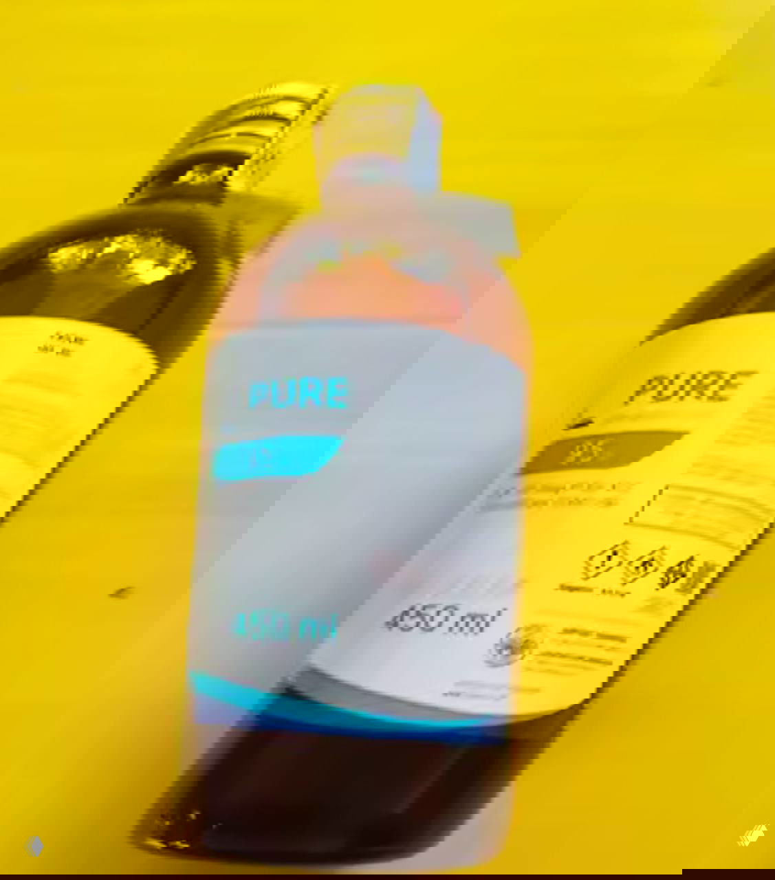 Коричневая бутылка с этикеткой "PURE 95" объёмом 450 мл на желтом фоне — рекламное фото спирта, подходящего для настоек и ликёров.