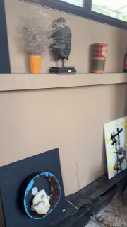 Интерьерное фото: полка с предметами декора, скульптурой и картинами — намёк на художественную атмосферу кафе, которое ведёт хозяйка-художница.