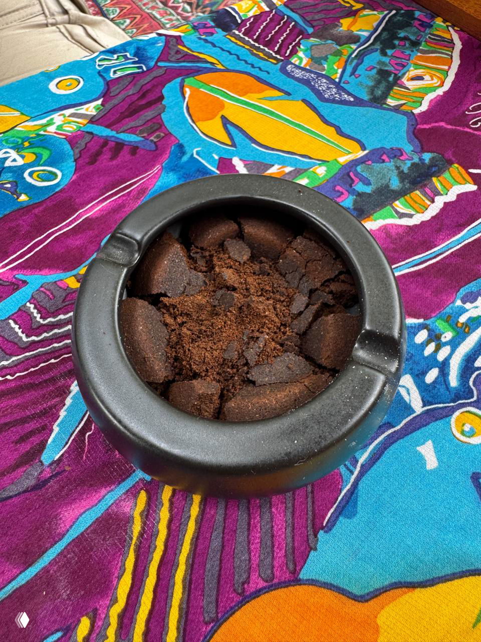 Пепельница, заполненная кофейным жмыхом вместо пепла, поставленная на яркую скатерть — необычная деталь сервиса и атмосферы кафе