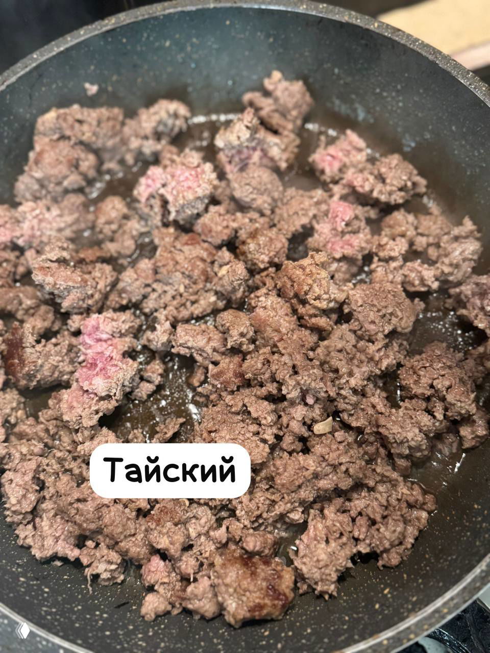 Обжариваемый тайский фарш в сковороде: более мелкие крошки, темнее по цвету и с меньшим видимым жиром, подпись «Тайский» — демонстрация другой текстуры и вкуса.