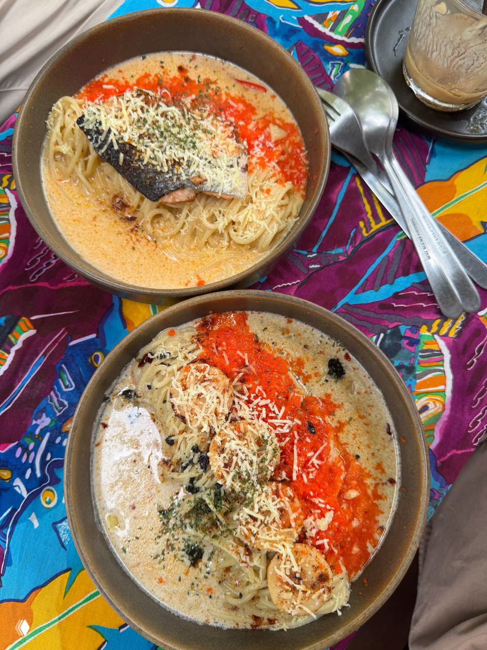 Две тарелки фьюжн-спагетти с морским гребешком, икрой ebiko, spicy creamy соусом и тертым сыром на яркой текстильной скатерти