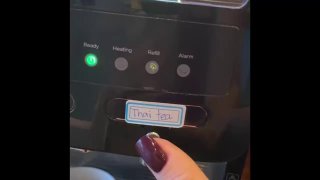 Крупный план кофемашины в ресторане с наклейкой «Thai tea» и пальцем у панели, иллюстрирует автоматический кофе с сахаром в White Nest.