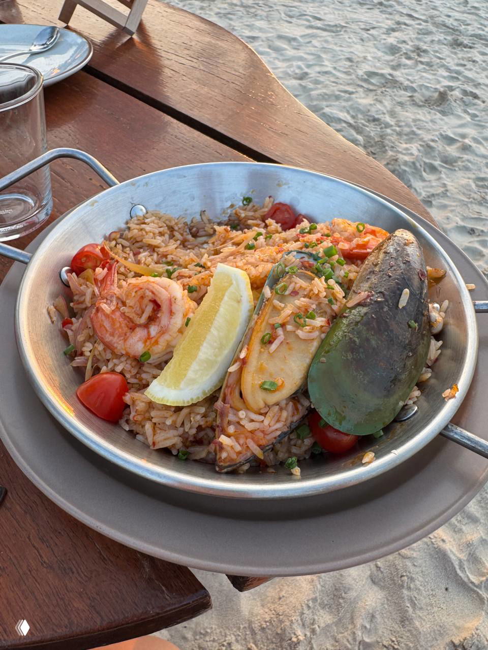 Порция Tom Yam fried rice с креветками, мидией, долькой лимона и помидорами в металлической сковороде — пляжная версия тайской паэльи.