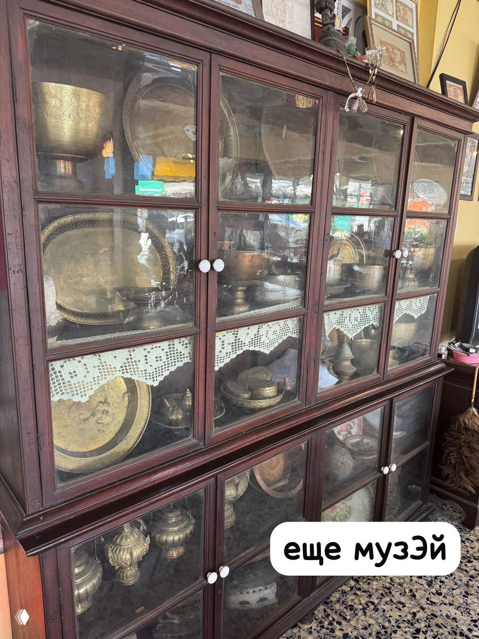 Ещё одна витрина с закрытыми стеклянными отсеками, внутри металлические блюда и кувшины, организация экспозиции хозяйки кафе.