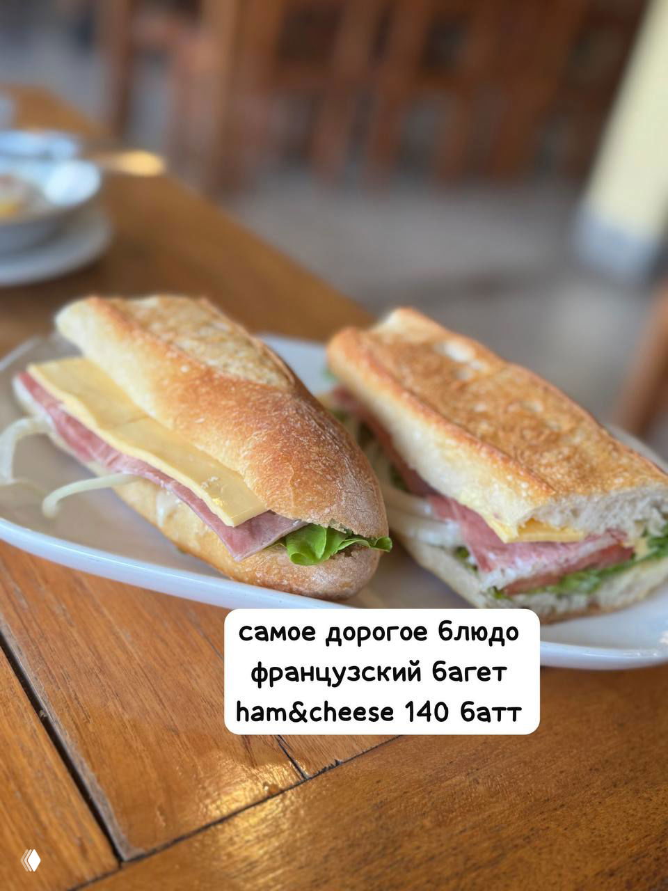 Два французских багета с начинкой ham & cheese на белой тарелке, золотистая корочка и ломтики сыра, подача как в туристическом меню.