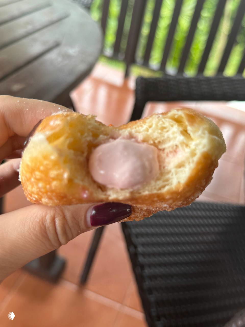 Разрезанный пончик с нежно-розовой начинкой крупным планом: плотная кремовая сердцевина и влажная текстура теста на закваске.