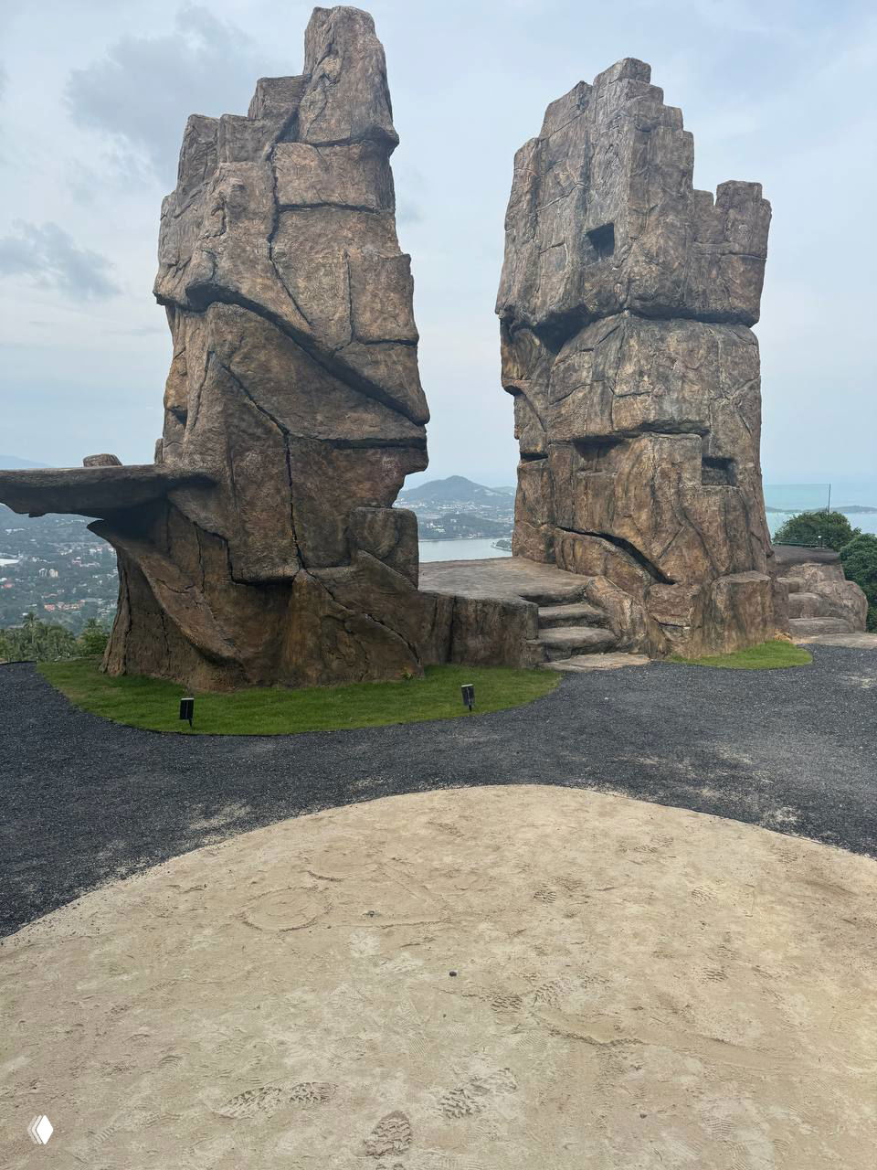 Каменные искусственные скалы и ступени как часть декора площадки для панорамных снимков с видом на залив.