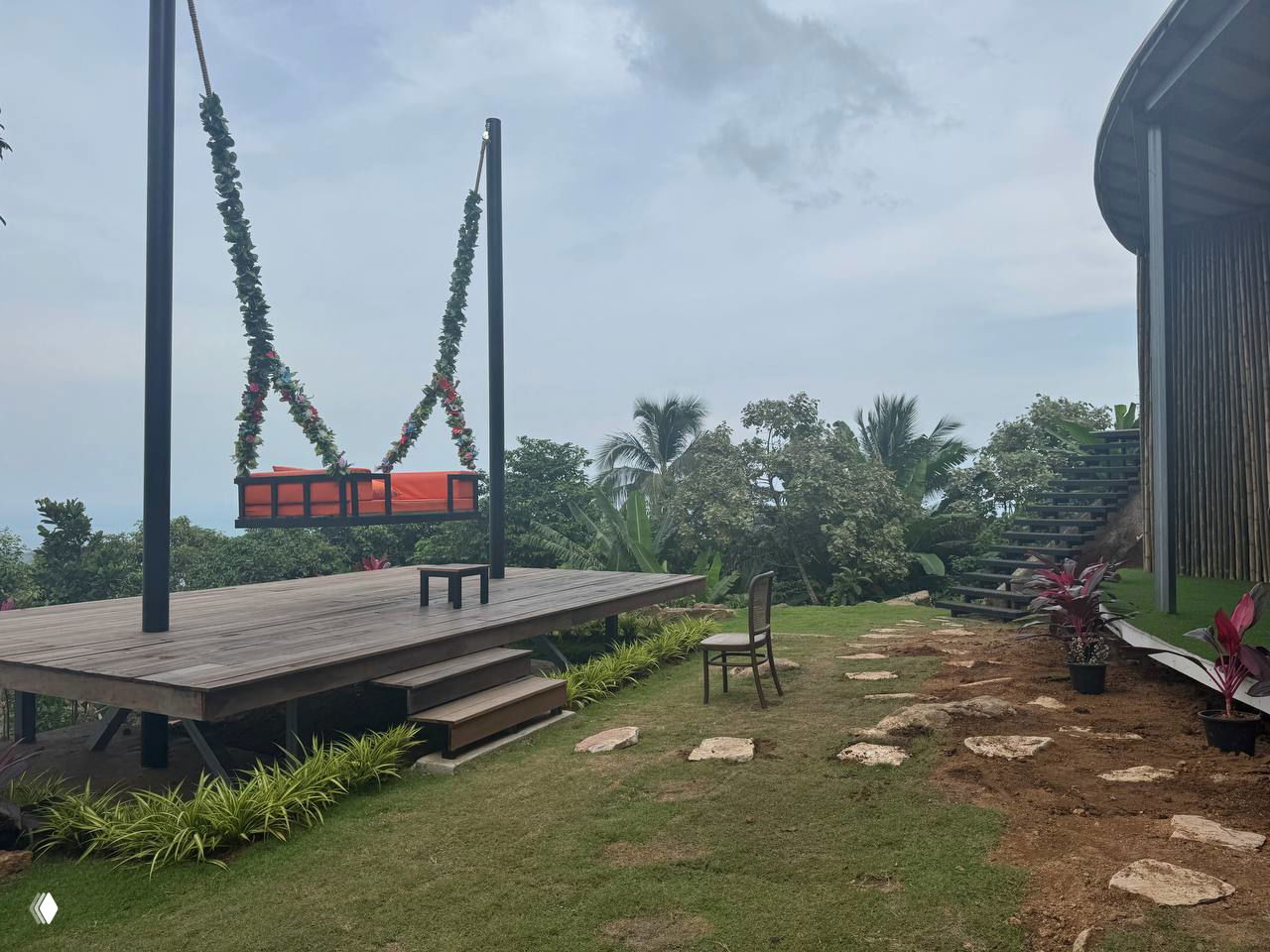 Платформа со свисающими цветочными качелями и видом на джунгли и море — одна из фотозон с реквизитом для снимков.