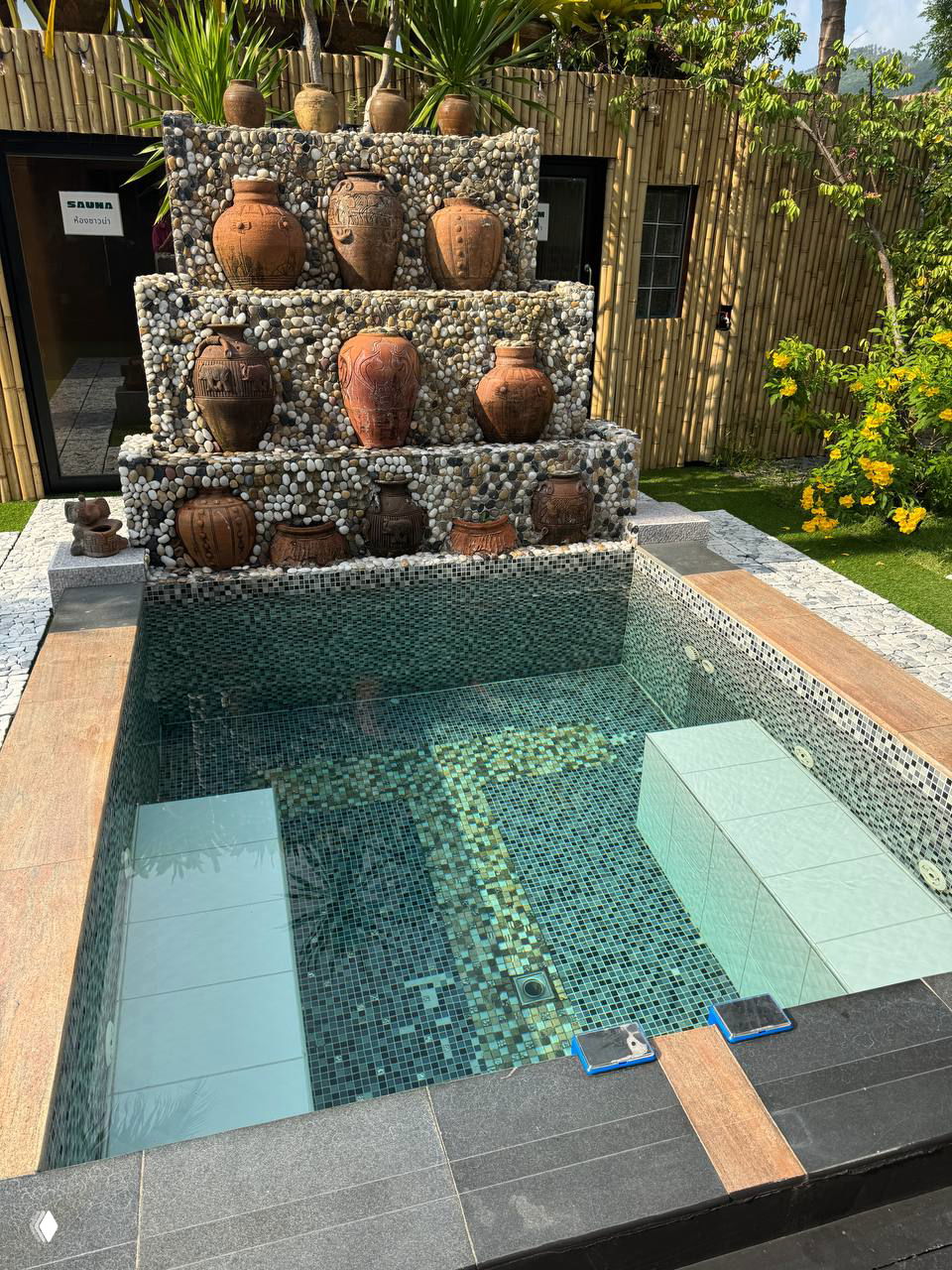 Небольшой мозаичный бассейн с ступенями и декоративной стеной из глиняных горшков — мини-бассейн на территории сауны Vihara.