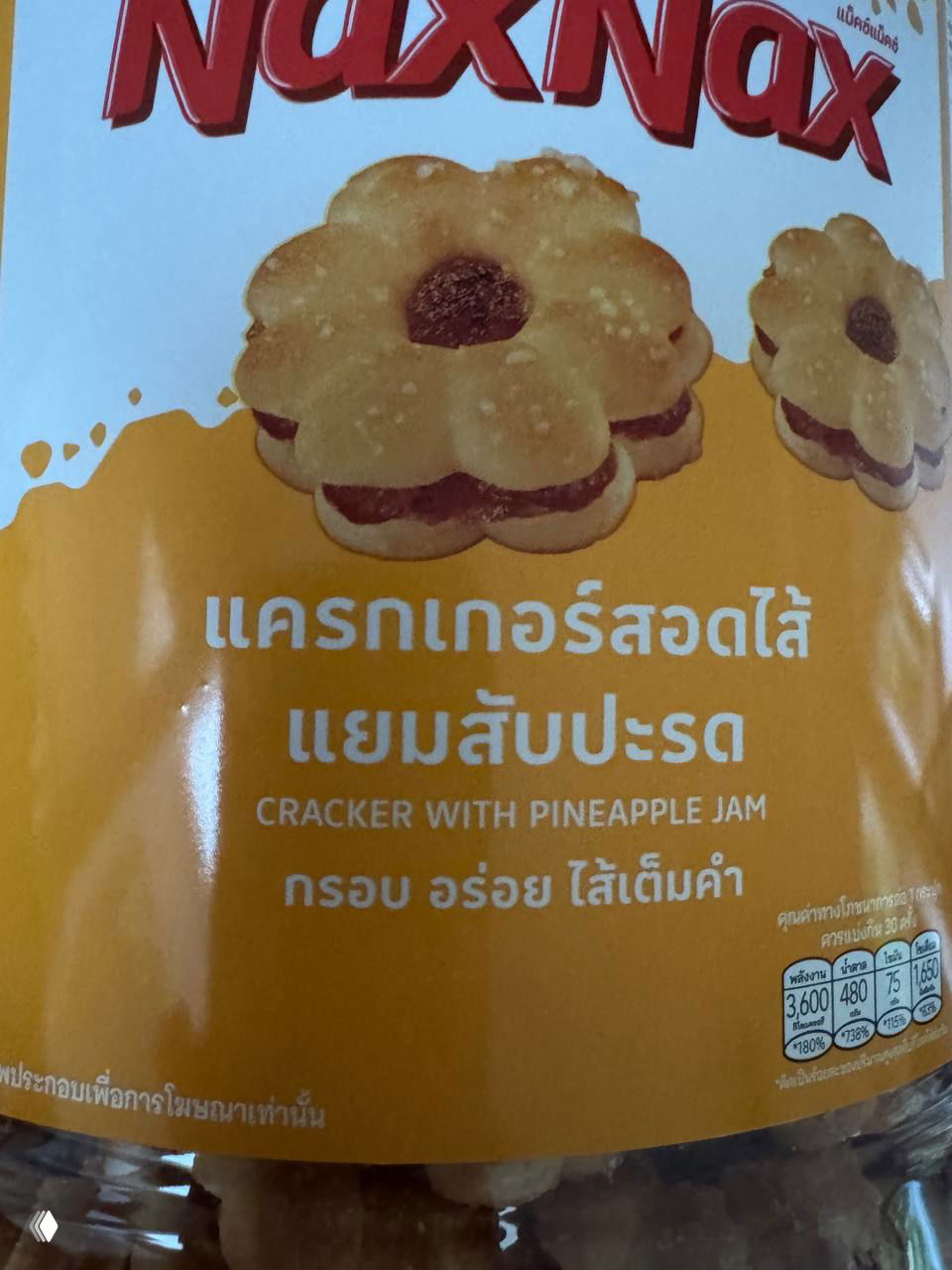 Этикетка упаковки NaxNax с изображением печенья и надписью на английском и тайском: "Cracker with pineapple jam", крупный план на банку.