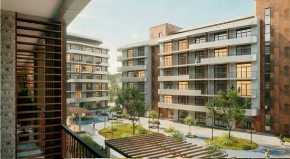 Вид с балкона на внутренний двор апарт‑комплекса: корпуса, озеленение, террасы и места для прогулок и отдыха.