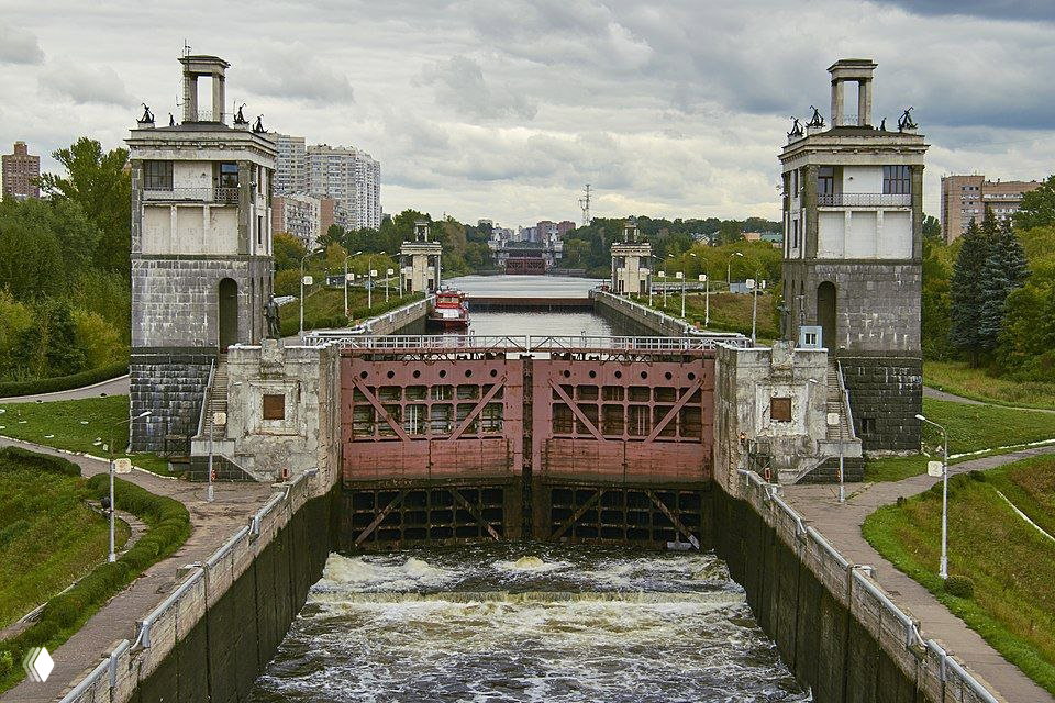 Шлюз с массивными воротами и башнями по бокам, проточная вода видна внизу — технический объект, который предстоит пройти по маршруту с 11 шлюзами.
