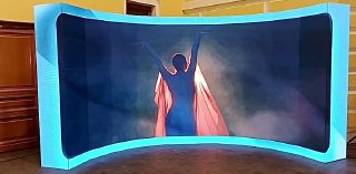 Полукруглая LED‑фотозона с подсветкой: центральный силуэт на экране и подсветка по кромке платформы, пример вечерней инсталляции.