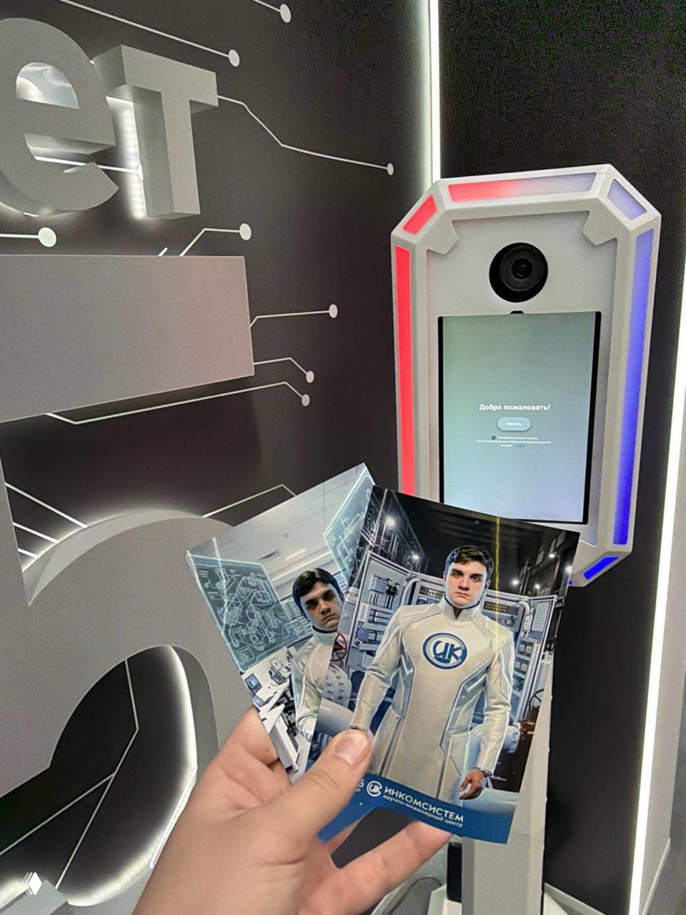 Крупный план фотостойки с цветной подсветкой и экраном; рука держит напечатанные фотографии с обработанным изображением человека в фирменном костюме.