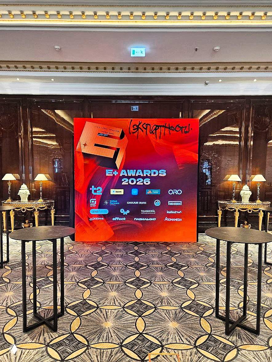 LED‑экран с красной промо‑графикой «EJ AWARDS 2026» в фойе, два высоких стола и настольные лампы по бокам