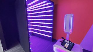 Фотостойка рядом с неоновым туннелем: сенсорный планшет для управления, зона для моментальной печати и светящаяся арка для эффектных кадров на событии.