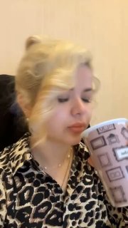 Крупный план женщины средних лет с собранными волосами и кружкой в руках — кадр из видео-отзыва выпускницы курса о похудении и переменах.