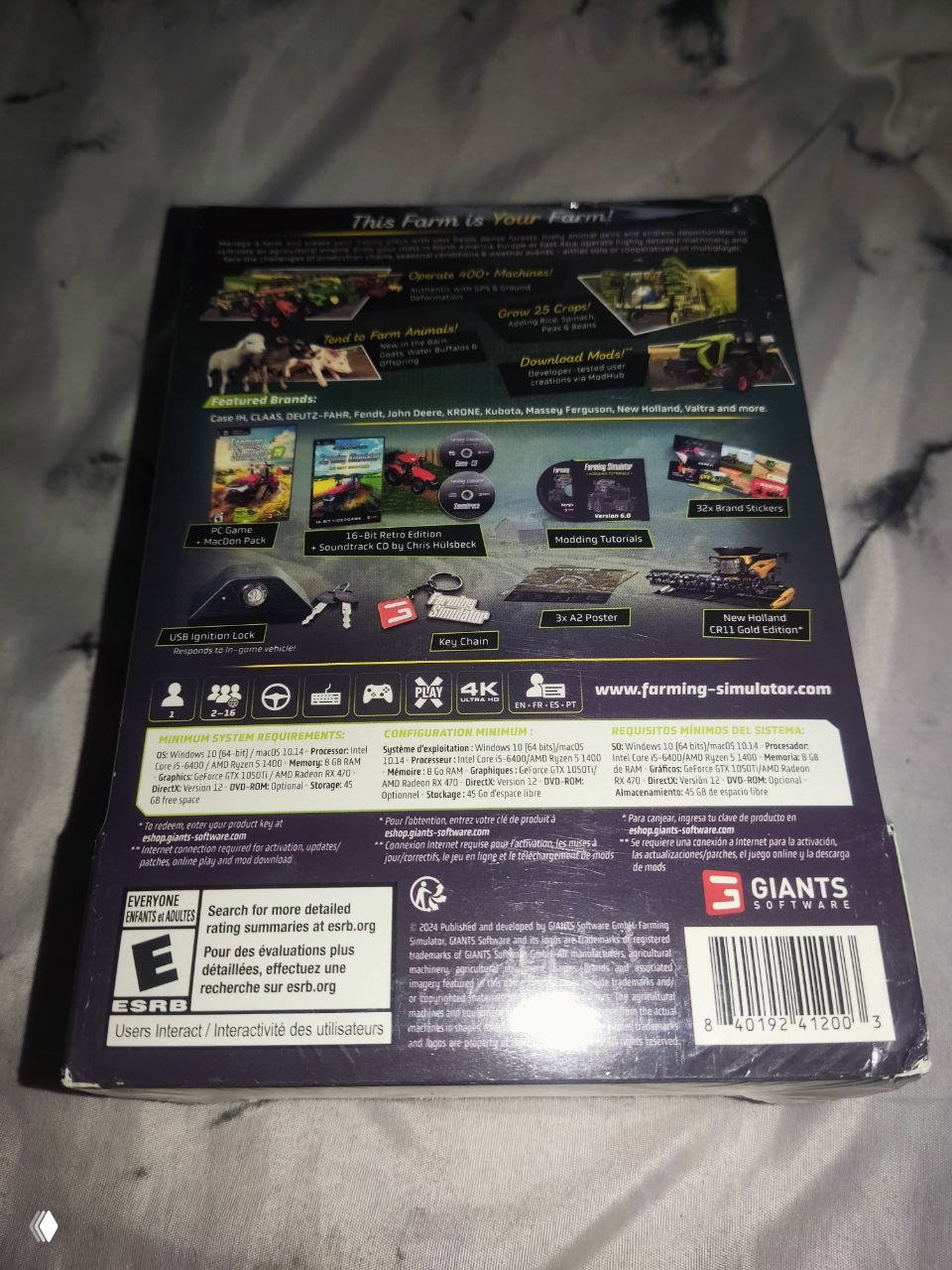 Обратная сторона коробки Farming Simulator 25 Collector's Edition с иллюстрациями комплекта: постеры, моды, наклейки и иконки системных требований.