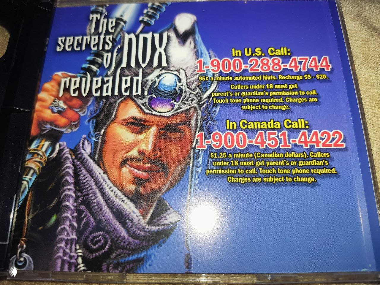 Обратная сторона обложки издания Nox с иллюстрацией персонажа и рекламой платных номеров 1-900 для справок и подсказок, снимок вкладыша крупным планом.