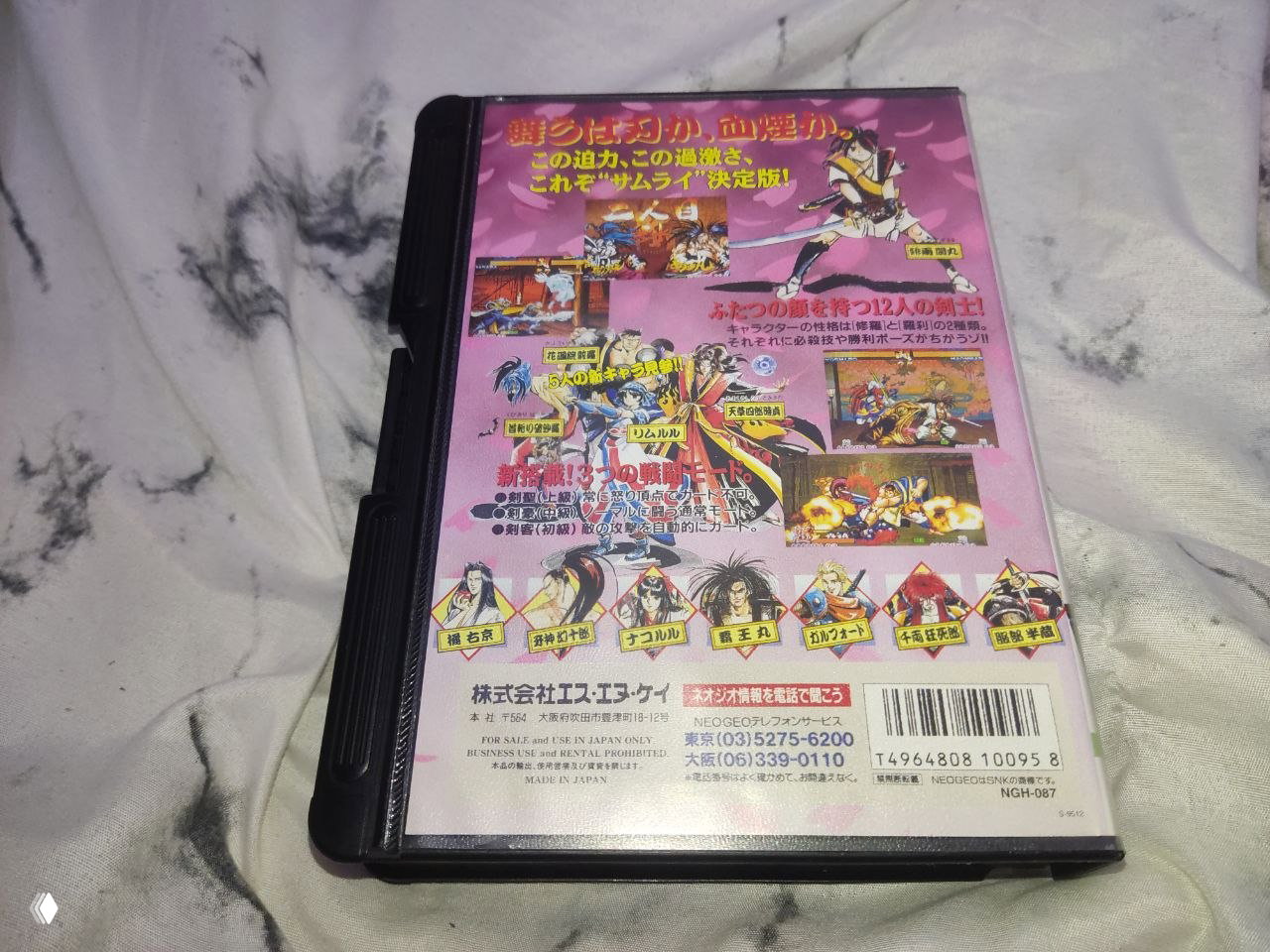 Фото обратной стороны обложки Samurai Spirits 3 (Neo Geo AES): задник с иллюстрациями персонажей, скриншотами, японским текстом и штрих‑кодом издательства.