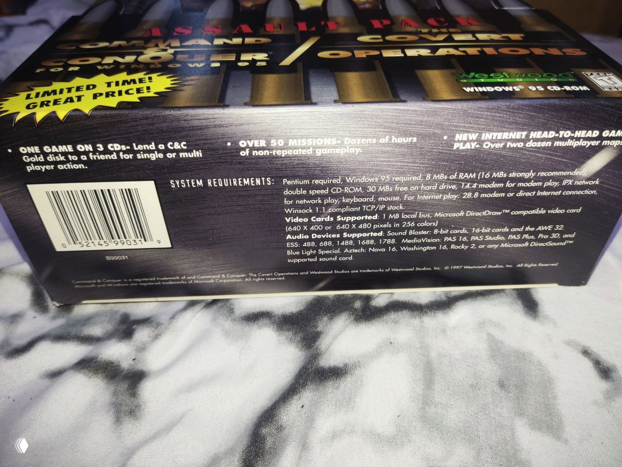 Фото тыльной стороны коробки Command & Conquer Assault Pack (1997): видна панель со штрихкодом, системными требованиями и мелким англоязычным текстом.