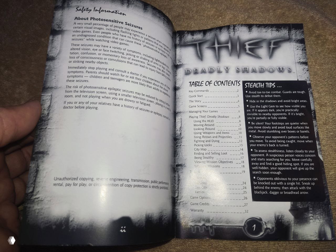 Развёрнутые страницы мануала Thief: Deadly Shadows — предупреждение о фотосенситивности, оглавление и игровыми советами в колонках, заметна нумерация.